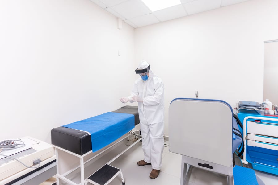 Healthcare worker wearing full protective equipment in a clinical room